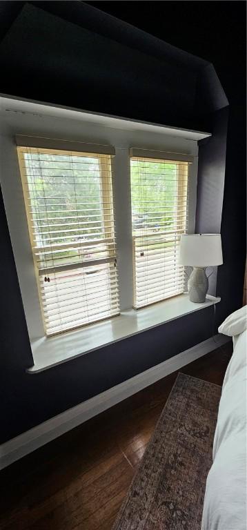 interior space featuring baseboards and dark wood-style floors