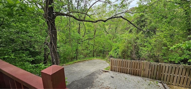 view of property's community with a forest view, fence, and a patio