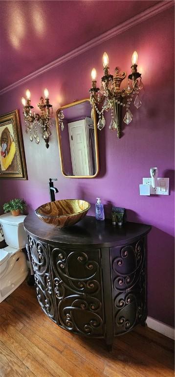 bathroom featuring hardwood / wood-style flooring, toilet, ornamental molding, and vanity