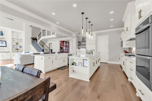 kitchen featuring open floor plan, appliances with stainless steel finishes, open shelves, light countertops, and ornamental molding