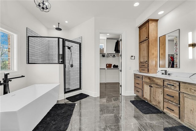 bathroom with a shower stall, vanity, marble finish floor, a freestanding bath, and recessed lighting