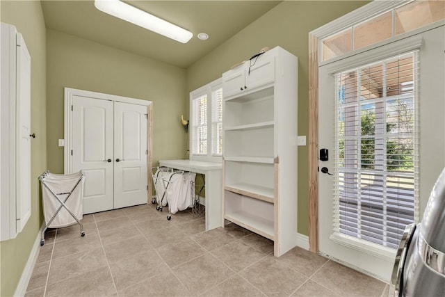 mudroom with baseboards, a wealth of natural light, and light tile patterned floors