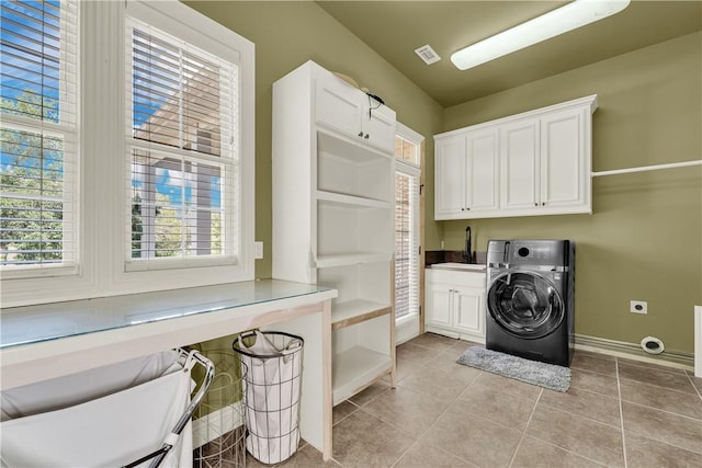 laundry room featuring a healthy amount of sunlight, a sink, washer / clothes dryer, and cabinet space