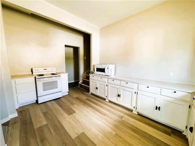 kitchen with white cabinets, light countertops, white appliances, and light wood-type flooring