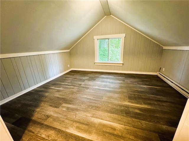 bonus room featuring a baseboard heating unit, vaulted ceiling, wood finished floors, and wood walls