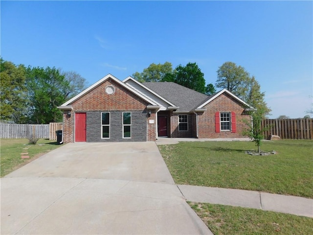 view of front facade featuring brick siding, concrete driveway, a front lawn, and fence