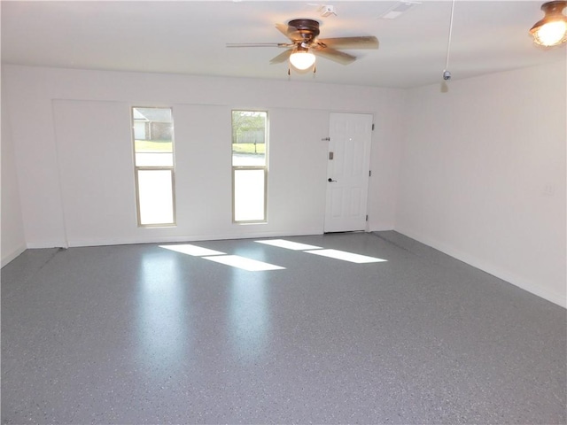 unfurnished room featuring a ceiling fan and baseboards