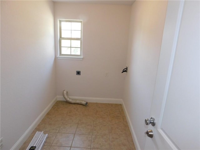washroom with light tile patterned flooring, baseboards, electric dryer hookup, and laundry area