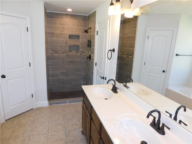 bathroom featuring tile patterned floors, a sink, and a tile shower