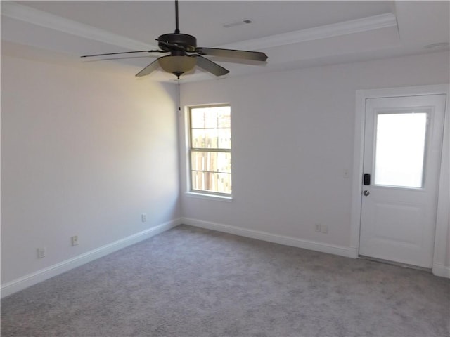spare room with visible vents, a ceiling fan, ornamental molding, carpet floors, and baseboards