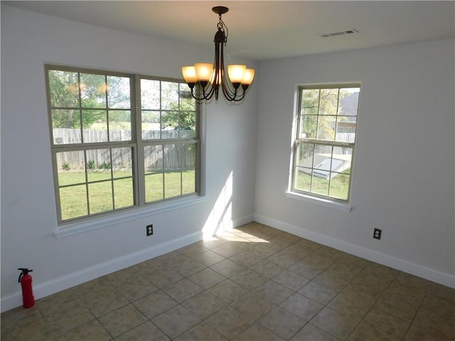 unfurnished dining area with an inviting chandelier, tile patterned flooring, visible vents, and baseboards