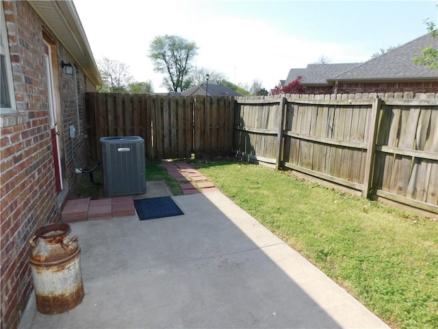 view of yard with a fenced backyard, central AC unit, and a patio