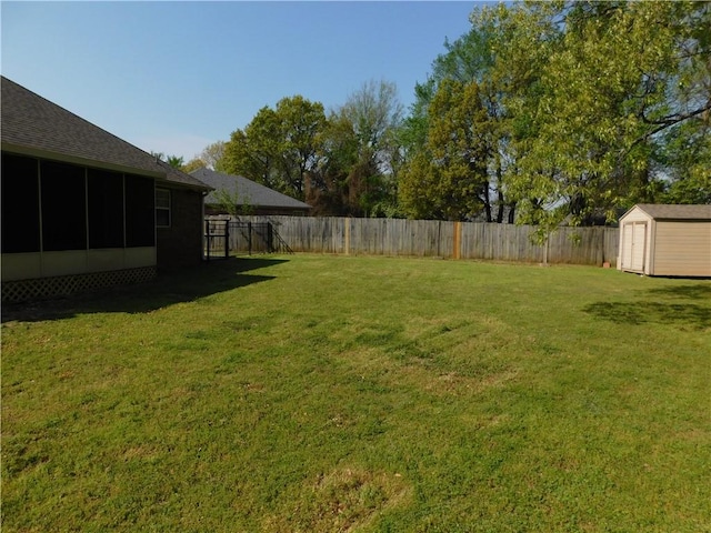view of yard with a fenced backyard, an outbuilding, and a shed
