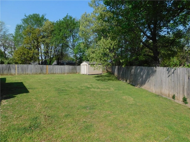 view of yard featuring a fenced backyard, a storage unit, and an outdoor structure