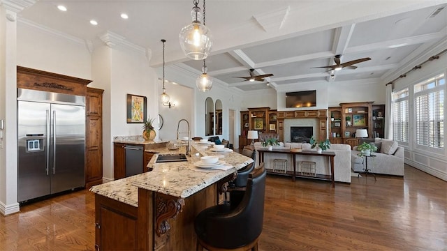 5309 S Promontory Ct, Rogers, AR 72758 - kitchen with built in refrigerator, ceiling fan, dark wood finished floors, coffered ceiling, and arched walkways
