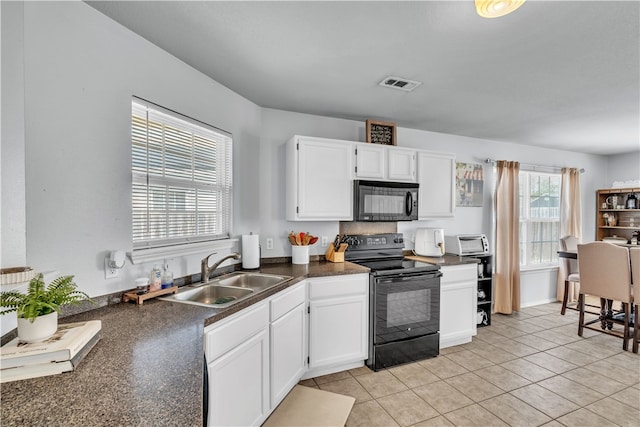 1908 S Pinewoods Dr, Rogers, AR 72758 - kitchen featuring dark countertops, visible vents, a sink, black appliances, and white cabinetry
