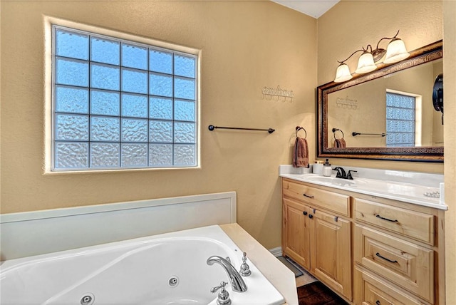 bathroom with a whirlpool tub and vanity