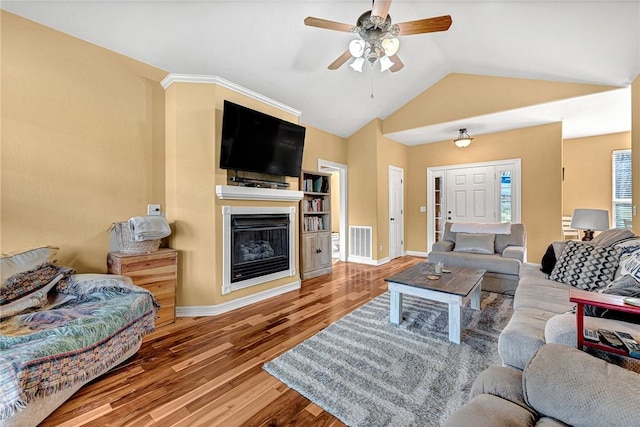 living room featuring baseboards, visible vents, lofted ceiling, wood finished floors, and ceiling fan