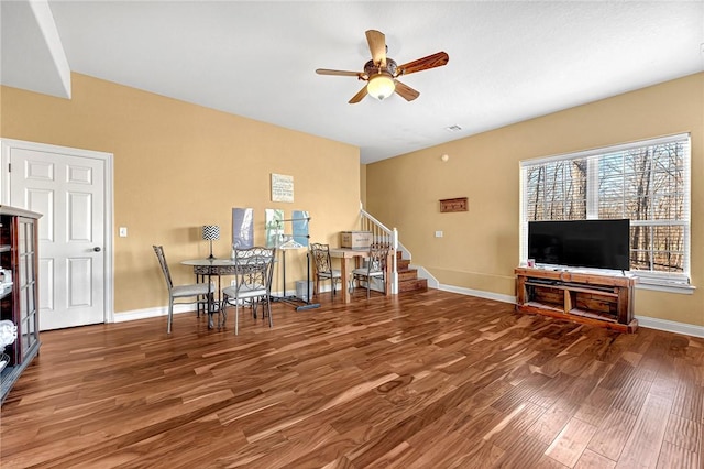 interior space featuring baseboards, a ceiling fan, and wood finished floors
