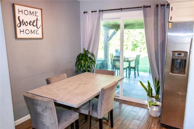 dining area with baseboards and dark wood-type flooring