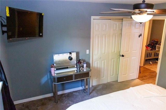 carpeted bedroom featuring a closet, baseboards, and ceiling fan