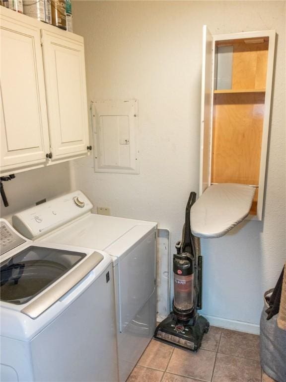 washroom with cabinet space, washing machine and dryer, light tile patterned floors, and electric panel