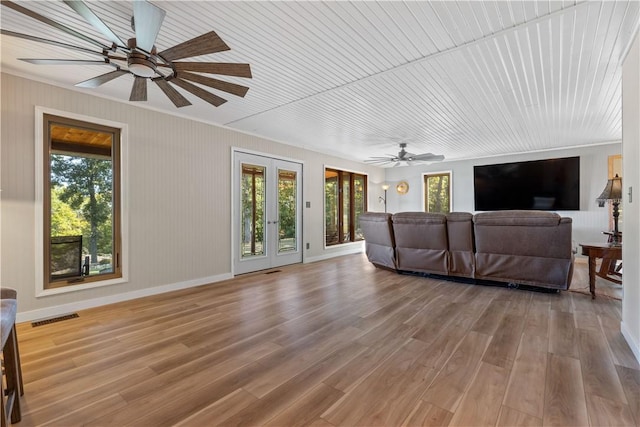 living area featuring ceiling fan, a wealth of natural light, and visible vents
