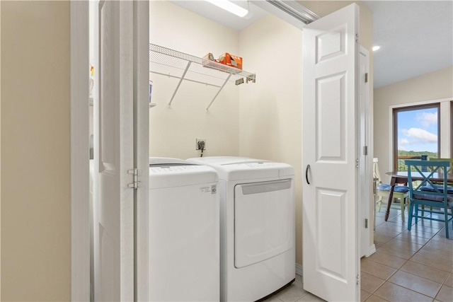 laundry room with washing machine and clothes dryer, laundry area, and light tile patterned floors