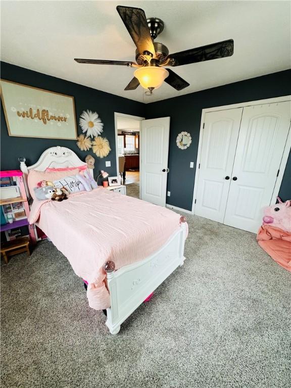 bedroom with ceiling fan, carpet floors, and a closet