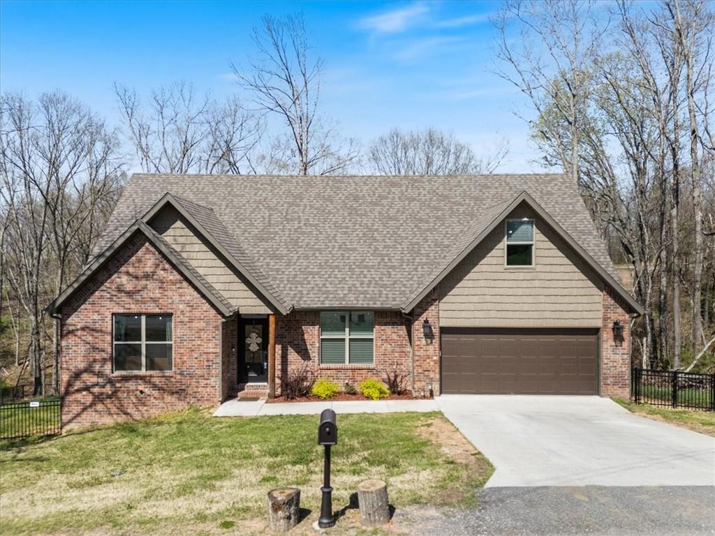 10 Singleton Dr, Bella Vista, AR 72715 - view of front of house featuring concrete driveway, a front lawn, fence, and brick siding
