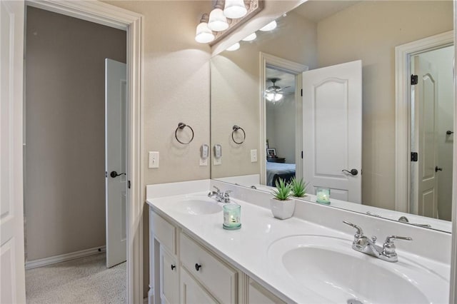 ensuite bathroom featuring ceiling fan, a sink, double vanity, and connected bathroom