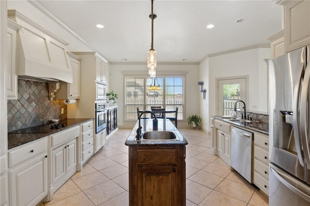 kitchen with decorative backsplash, stainless steel appliances, a kitchen island with sink, and a sink
