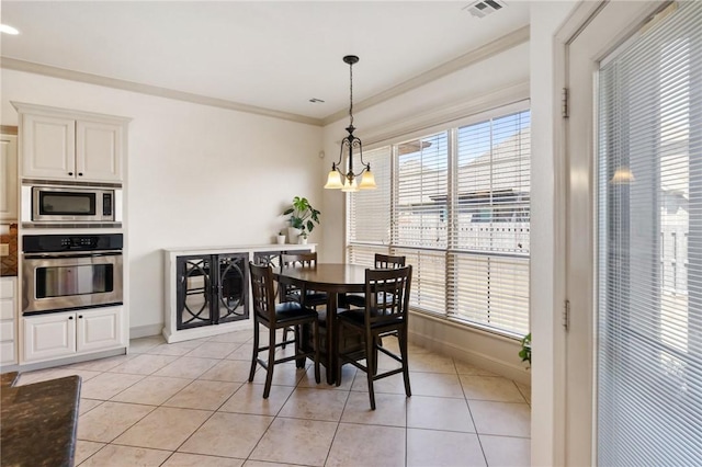 dining room with visible vents, baseboards, light tile patterned floors, and ornamental molding