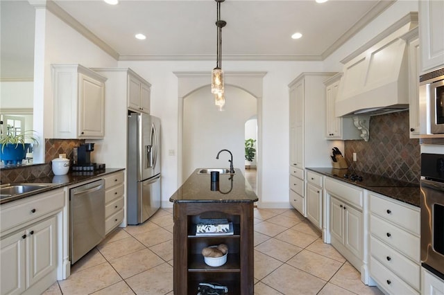 kitchen with open shelves, a sink, arched walkways, a kitchen island with sink, and appliances with stainless steel finishes