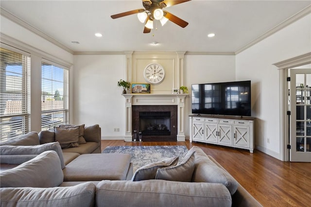 living room featuring a ceiling fan, baseboards, ornamental molding, and wood finished floors