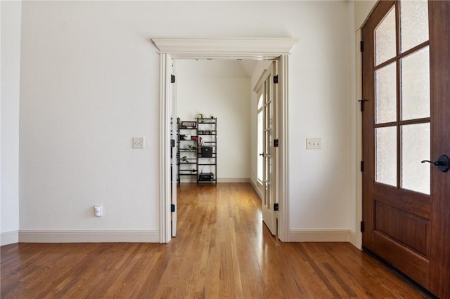 foyer entrance with light wood finished floors, french doors, baseboards, and a healthy amount of sunlight