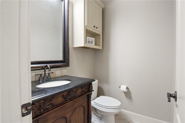 bathroom featuring tile patterned flooring, toilet, vanity, and baseboards
