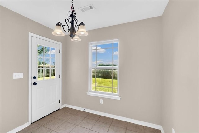 doorway featuring light tile patterned floors, an inviting chandelier, visible vents, and baseboards