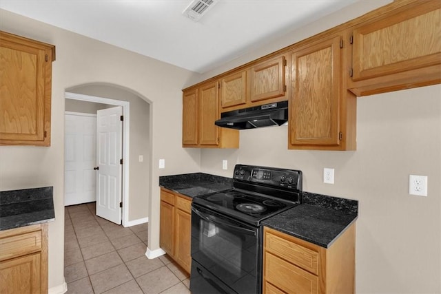 kitchen featuring under cabinet range hood, visible vents, black range with electric stovetop, light tile patterned floors, and arched walkways