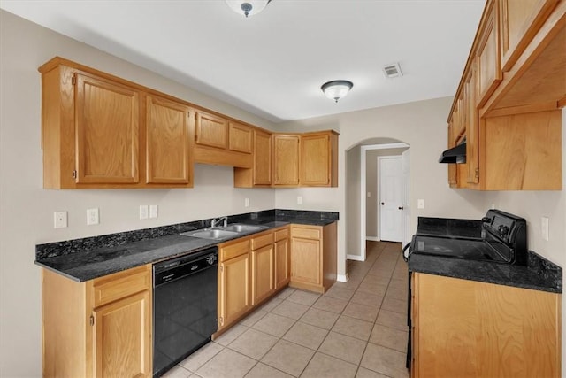 kitchen featuring under cabinet range hood, light tile patterned floors, arched walkways, a sink, and black dishwasher