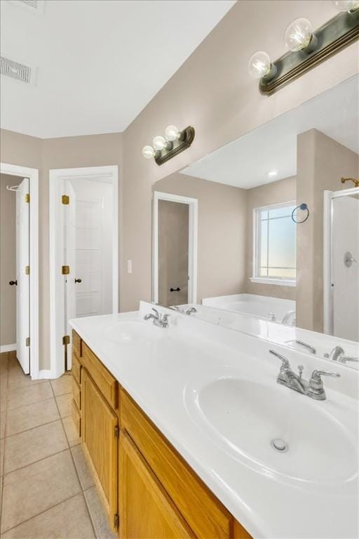 full bath with double vanity, a washtub, tile patterned floors, and a sink