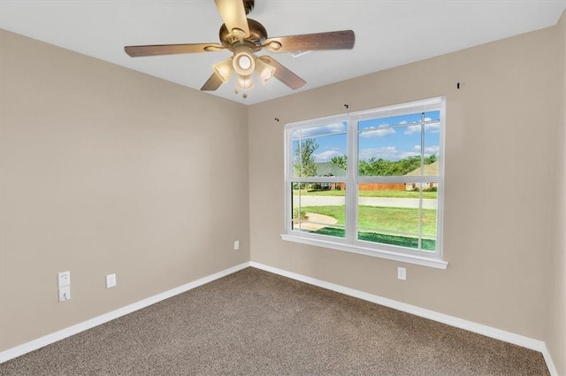 empty room featuring a ceiling fan, baseboards, and dark carpet