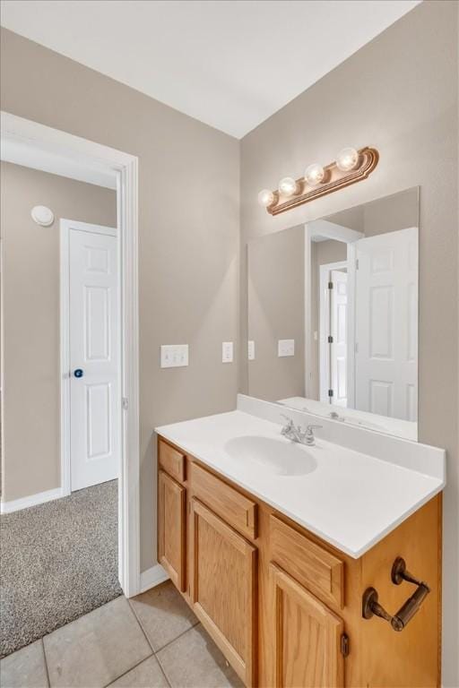 bathroom with vanity, baseboards, and tile patterned flooring