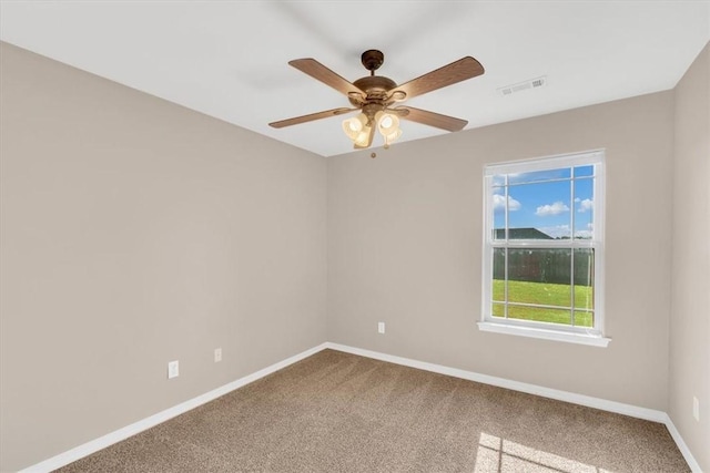 spare room with visible vents, carpet flooring, baseboards, and ceiling fan