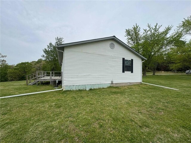view of home's exterior featuring a lawn and a deck