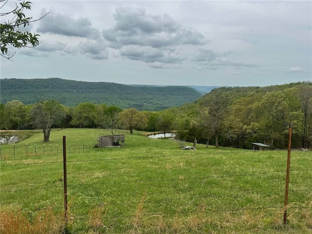 view of mountain feature featuring a rural view, a wooded view, and a water view