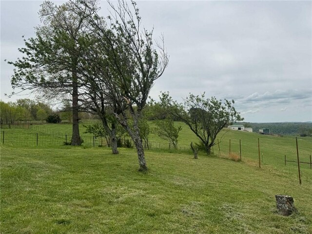 view of yard featuring fence and a rural view