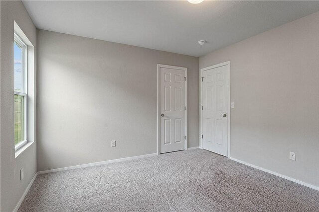 carpeted spare room with baseboards