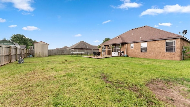 505 Blair Cir, Pea Ridge, AR 72751 - back of house featuring a trampoline, an outbuilding, a fenced backyard, a shed, and a yard