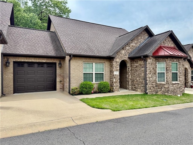 view of front of home with an attached garage, driveway, roof with shingles, and stone siding